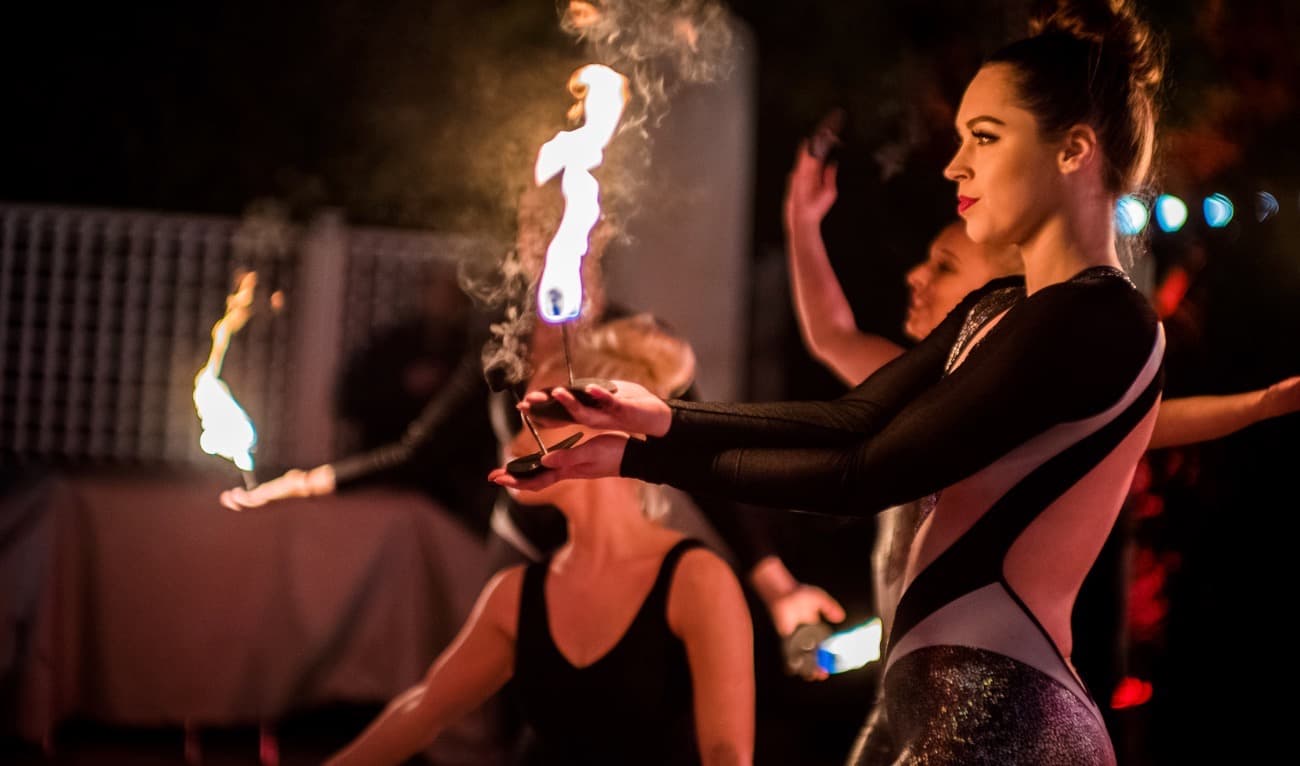 Fire dancers perform at a party. Girls balance flames on thier hands