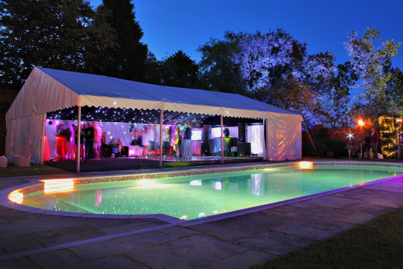 Pool Party Perfection A marquee is set on the side of a swimming pool at dusk