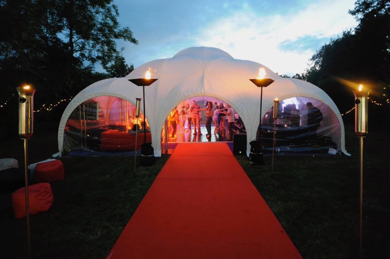 Red carpet leading to a Dome Marquee with flames at the entrance