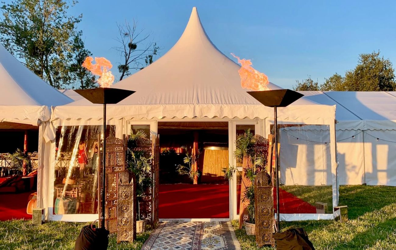 A Pagoda marquee with clear sides and real flame flambeaux 