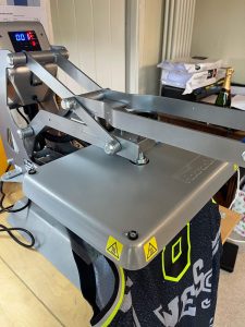 An NBA basketball jersey on a heat press being personalised
