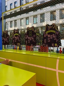 The corner shop at Selfridges, Oxford Street set up with basketball jerseys to personalise NBA jerseys for Hennessy. 4 personalised jerseys are in the window.