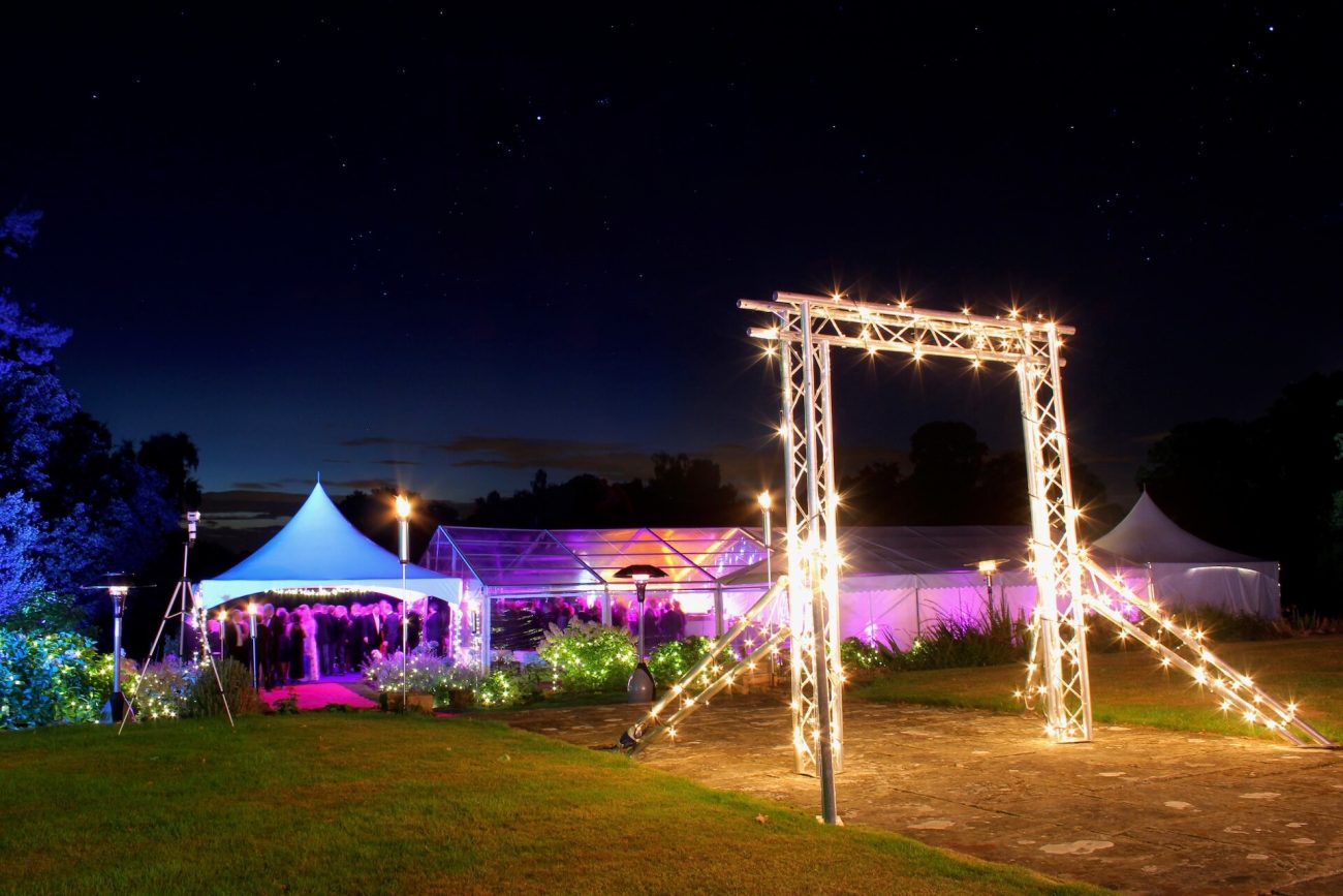 Frame Marquee and Pagoda on a tennis court for a party as dusk falls.