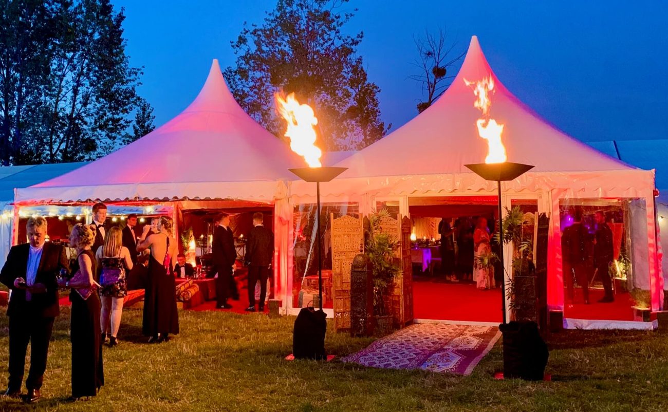Two pagoda marquees with flame flambeaux ready for a party